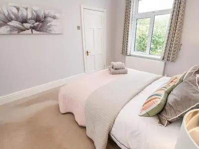 a bedroom with a bed with a teddy bear on it at Robin Hill in St Austell