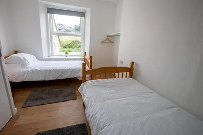a room with two beds and a window at OA Surf Club in Bude