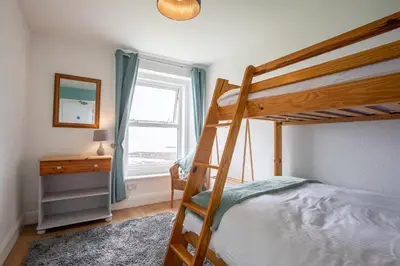 a bedroom with a bunk bed and a mirror at OA Surf Club in Bude