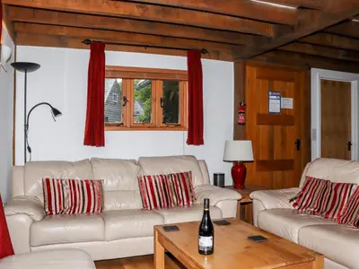 a living room with two white couches and a table at Bybrook Lodge in Camelford