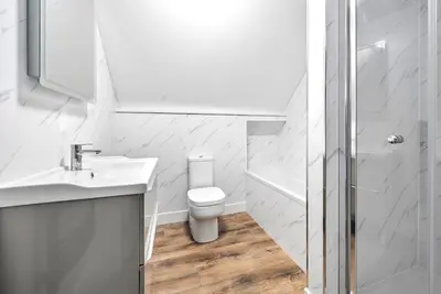 a bathroom with a toilet and a sink and a shower at Pochin House Collections in St Austell