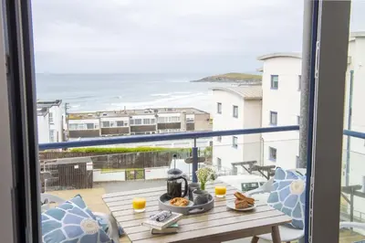 a balcony with a table and a view of the ocean at Ocean lookout & explore the coast in Newquay