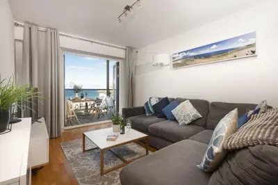 a living room with a couch and a table at Ocean lookout & explore the coast in Newquay