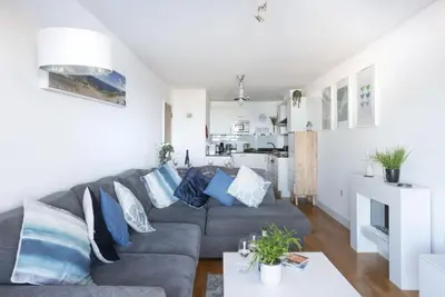 a living room with a gray couch and blue pillows at Ocean lookout & explore the coast in Newquay