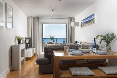 a living room with a couch and a table at Ocean lookout & explore the coast in Newquay