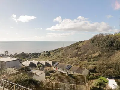 a row of houses on a hill next to the ocean at Ocean View in Torpoint