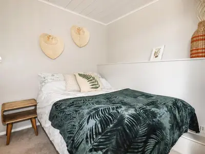 a bedroom with a bed with a green blanket at Ocean View in Torpoint