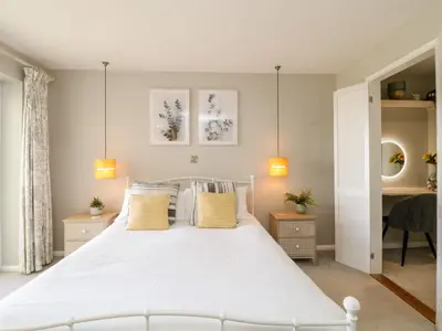 a bedroom with a white bed with yellow pillows at Ocean View in Torpoint
