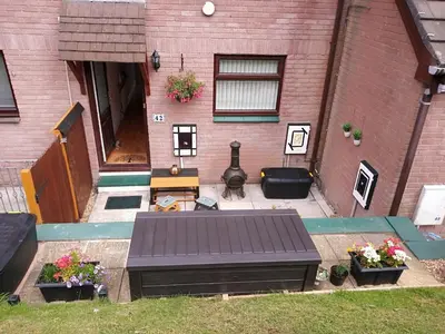 a patio with a bench in front of a building at West Looe Downs in Looe