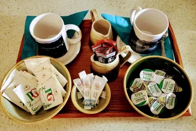 a wooden tray with two cups and some tea packets at West Looe Downs in Looe