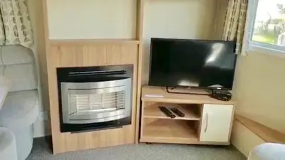 a tv sitting on a stand next to a television at NB12 Entire Caravan - Newquay in Porth