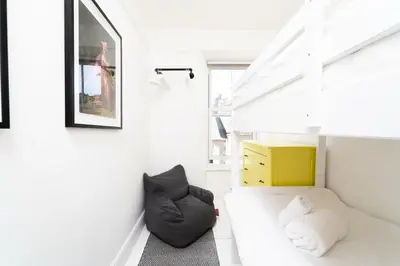 a white room with a bed and a yellow cabinet at St Hilary in St Ives