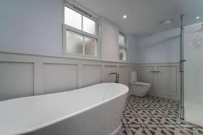 a white bathroom with a tub and a toilet at St Hilary in St Ives