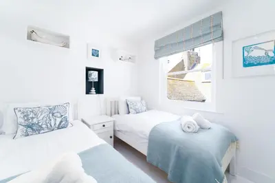 a bedroom with two beds and a window at St Ives House in St Ives