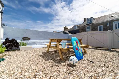 a wooden picnic table with a soccer ball and a skateboard at Victoria House in St Ives