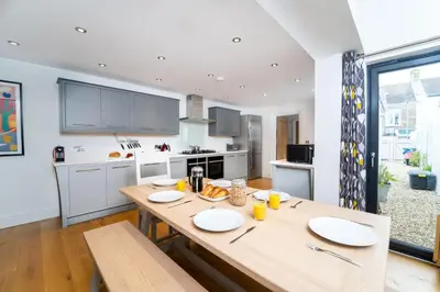 a kitchen with a wooden table with plates on it at Victoria House in St Ives