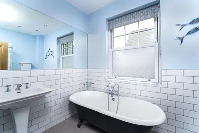 a bathroom with a bath tub and a sink at Victoria House in St Ives