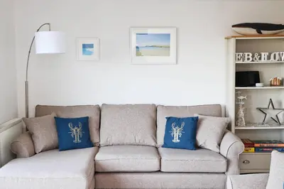 a living room with a couch with blue pillows at Holiday home with Estuary Views, parking & balcony in Padstow