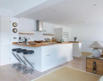 a kitchen with two bar stools and a counter top at Slipway 19 in Padstow