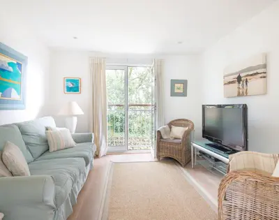 a living room with a couch and a flat screen tv at Slipway 19 in Padstow