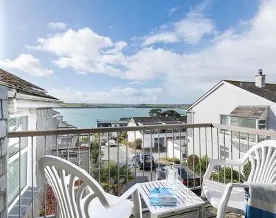 a balcony with white chairs and a view of the ocean at Slipway 19 in Padstow