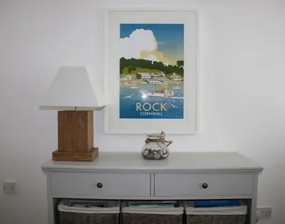 a white dresser with a picture on the wall at Slipway 10 in Padstow