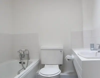 a white bathroom with a toilet and a sink at Slipway 10 in Padstow
