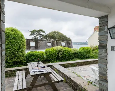 a wooden bench sitting on top of a patio at Slipway 10 in Padstow