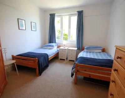 a bedroom with two beds and a window at Gullsway Sandpiper in Polzeath