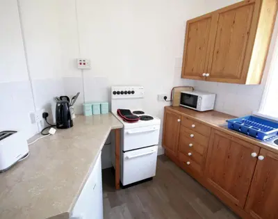 a small kitchen with a white stove top oven at Gullsway Sandpiper in Polzeath