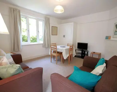 a living room with two couches and a table at Gullsway Sandpiper in Polzeath