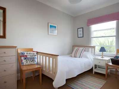 a bedroom with a crib and a bed and a window at Lowenna Manor 4 in Padstow