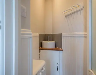 a white bathroom with a sink and a toilet at Folly 2 in Port Isaac