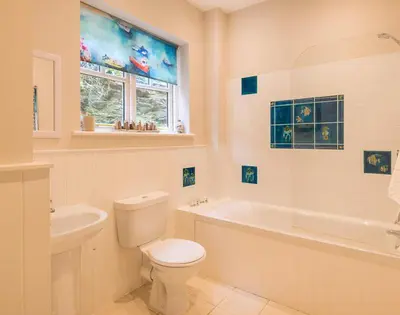 a bathroom with a toilet and a tub and a sink at Folly 2 in Port Isaac