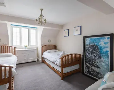 a bedroom with two twin beds and a chandelier at Folly 2 in Port Isaac