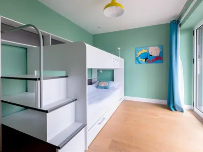 a room with a bunk bed and a bedroom with blue walls at Epphaven in Polzeath