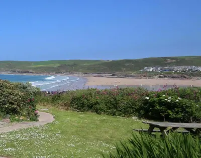 a picnic table sitting on the grass near a beach at Gullsway September Tide in Polzeath