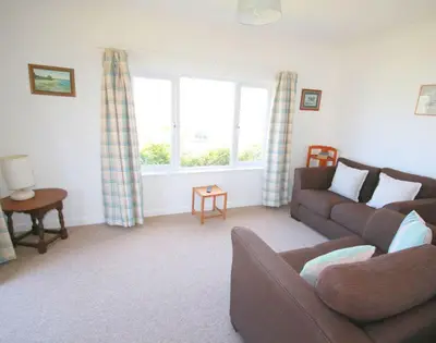 a living room with a couch and a window at Gullsway September Tide in Polzeath