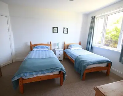 two twin beds in a room with a window at Gullsway Kittiwake in Polzeath