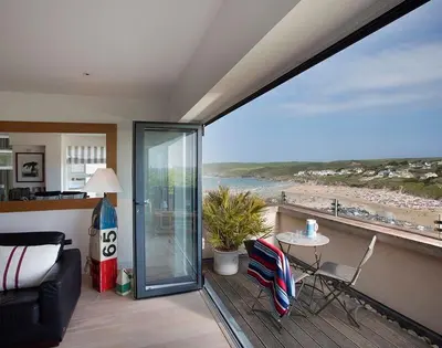 a living room with a balcony with a view of the beach at Kellan in Polzeath