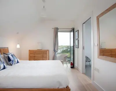 a bedroom with a large white bed and a window at Kellan in Polzeath