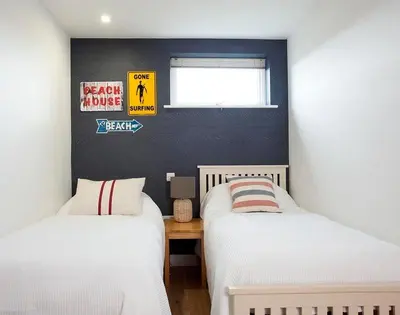 a bedroom with two beds and a window at Kellan in Polzeath
