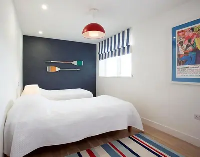 a bedroom with a white bed and a blue wall at Kellan in Polzeath
