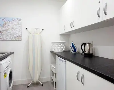 a white kitchen with a washer and dryer at Kellan in Polzeath