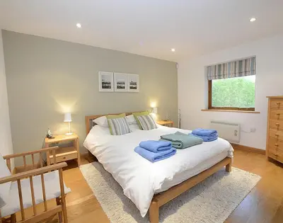 a bedroom with a large bed with blue towels on it at Sandy Hills 8 in Padstow
