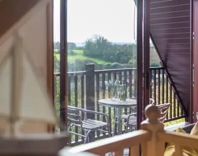 a balcony with a table and chairs on a porch at Sandy Hills 8 in Padstow