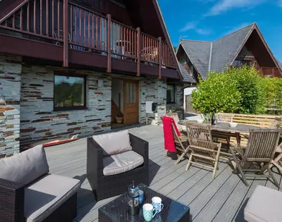 a patio with chairs and a table on a deck at Sandy Hills 8 in Padstow