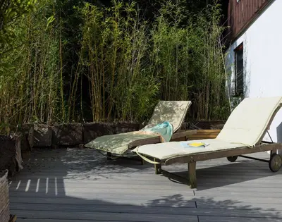 two lounge chairs and a bed on a patio at Sandy Hills 8 in Padstow