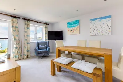 a living room with a table and a chair at Rock Lobster in Port Isaac