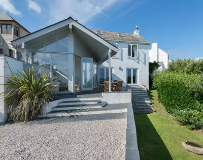 a white house with glass doors and stairs at Signal Post in Port Isaac
